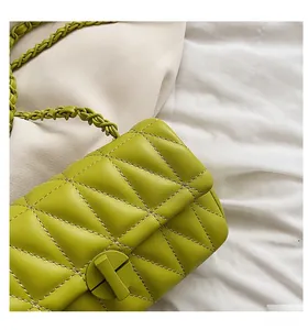 Detail of green quilted leather bag with diamond stitching and metal twist lock