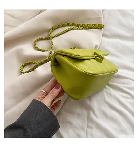 Detail of lime green quilted crossbody bag with textured chain strap and square buckle