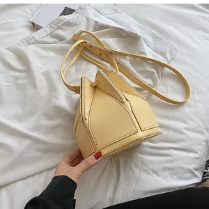 Detail view of the yellow geometric bucket bag with stitching and foldable leather panels