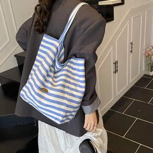 Blue and white striped canvas tote bag with long shoulder strap and handmade metal tag