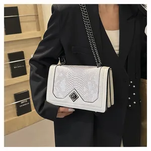 Detail of white snakeskin texture flap bag with metal chain strap and turn-lock closure