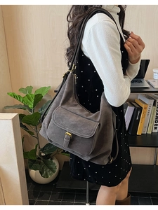 Détail du sac cabas en daim gris avec surpiqûres blanches et boucle dorée élégante