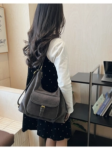 Détail du sac hobo gris foncé montrant la texture brossée et la boucle dorée
