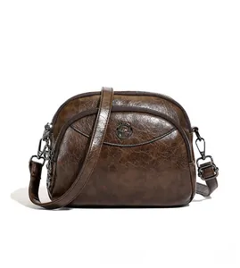 Detail view of dark brown retro leather handbag with vintage texture and golden kangaroo logo