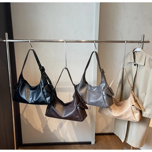 Sacs hobo en noir, marron, gris et beige sur support montrant un design minimaliste