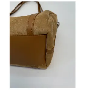 Detail view of reinforced bottom base and suede texture on caramel brown tote bag