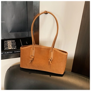 Detail of caramel woven leather tote bag featuring classic intrecciato texture and knotted straps
