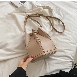 Detail of light beige geometric puzzle bucket bag showing the unique leather patchwork