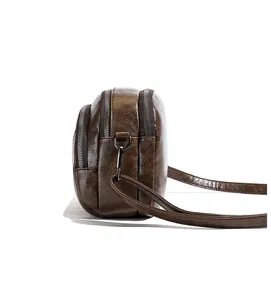 Side view showing multi-layer zipper compartments and soft textured brown leather bag