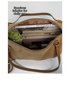 Spacious interior of brown matte leather tote bag holding books and a green umbrella