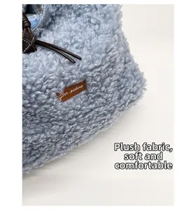 Macro view of blue plush handbag featuring faux shearling texture and leather drawstring