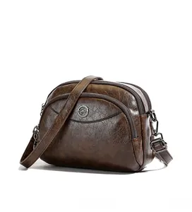 Close-up of vintage brown leather crossbody bag featuring three zipper pockets and kangaroo logo