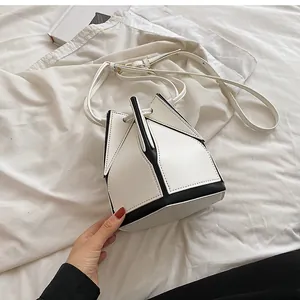 Detail view of the geometric folding structure and black and white contrast bucket bag