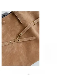 Detail view of caramel brown tote bag showing textured leather and white stitching