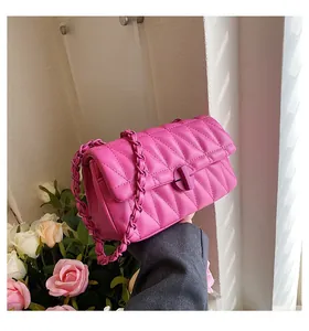 Detail of pink quilted handbag showing V-shaped embroidery and chain strap