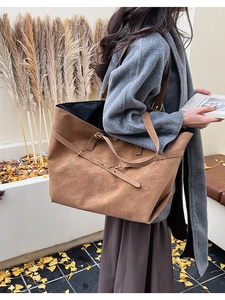 Close-up of brown suede tote bag with decorative straps and fine leather texture