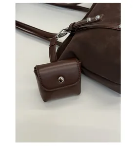 Close-up of a brown faux leather mini coin purse with silver buckle detail on a handbag