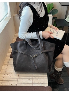 Detailed view of large dark grey tote bag with premium matte leather texture and gold hardware
