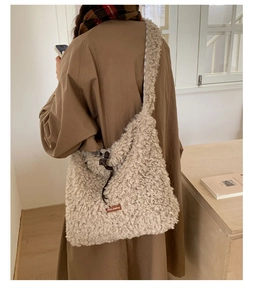 Close-up of beige plush tote bag with Star-picking leather tag and drawstring detail