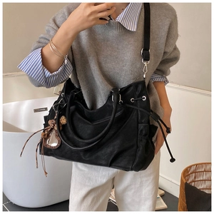 Close-up of black canvas tote bag with side drawstring and leopard heart charm