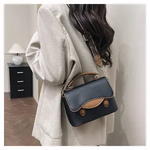 Vue de dos d'un sac bandoulière en cuir noir grainé avec des finitions marron chic