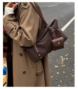 Detail of retro brown shoulder bag with silver rivets and matching mini coin purse