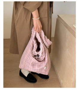 Detail of pink plaid tote bag with soft white faux fur trim and cozy autumn style