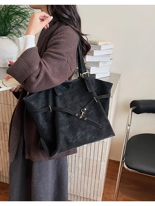 Detailed view of matte black retro tote bag with adjustable metal buckle on shoulder strap