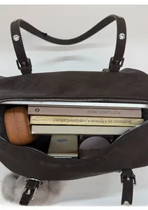 Vista dall'alto dell'interno capiente della borsa tote in pelle marrone con tablet e libri
