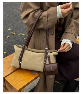 Detail of khaki suede tote bag featuring silver studs and a mini hanging coin purse
