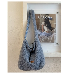 Detailed view of blue faux shearling tote bag with textured fleece and leather star label