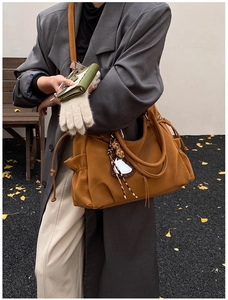 Detail of caramel leather tote bag showing soft texture and stylish drawstring side