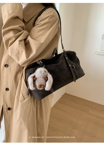 Dettaglio borsa tote in pelle scamosciata marrone scuro con ciondolo a coniglio