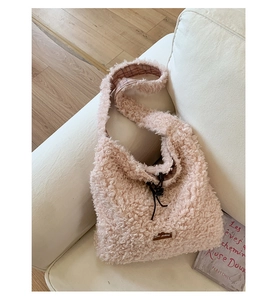 Detailed view of pink fleece tote bag with drawstring closure and brown leather tag