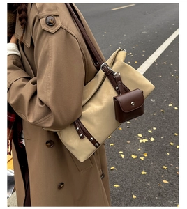 Detailed view of a retro two-tone shoulder bag with leather straps and a side pouch