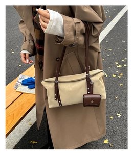 Chic beige tote bag with brown straps and matching vintage earphone case detail