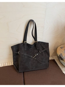 Detail of the vintage large tote bag with textured leather and metal buckle hardware