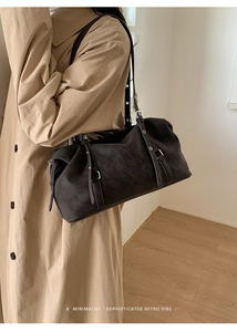 Dettaglio della borsa Boston retrò in scamosciato con spalline in pelle e occhielli argentati
