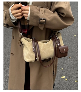 Detail of beige suede shoulder bag with brown leather straps and matching mini pouch accessory