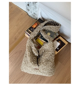 Detail of beige fleece tote with brown leather drawstring and checkered lining