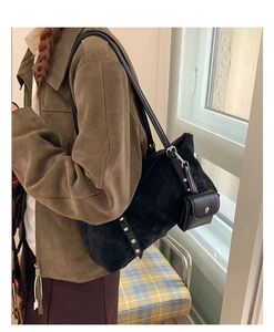 Detail of vintage black suede hobo bag with metal rivets and small hanging pouch