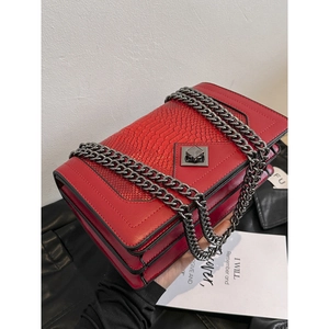 Red snakeskin textured crossbody bag with gunmetal chain strap and flap closure