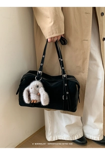 Borsa tote minimalista in pelle nera con ciondolo a forma di coniglio di peluche su modella