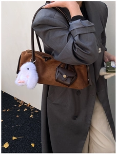 Nahaufnahme der braunen Wildledertasche mit flauschigem Hasen- und Lederanhänger