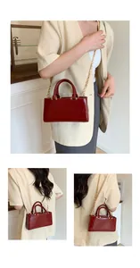 Deep red leather crossbody bag featuring gold chain strap and elegant circular handle