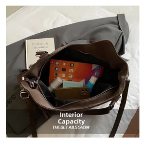 Internal capacity of the large brown tote bag showing a tablet and daily essentials