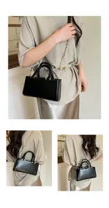 Detail of minimalist black glossy leather crossbody bag with elegant gold chain strap