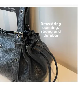 Close-up of black lychee grain leather tote with durable drawstring closure and silver eyelets