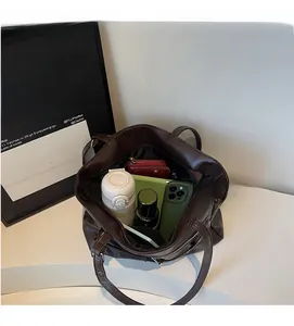 Interior view of large brown leather tote bag showing spacious storage for tablet and wallet