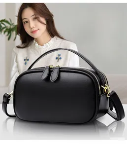 Close-up of black lychee grain leather handbag with premium gold zipper and top handle